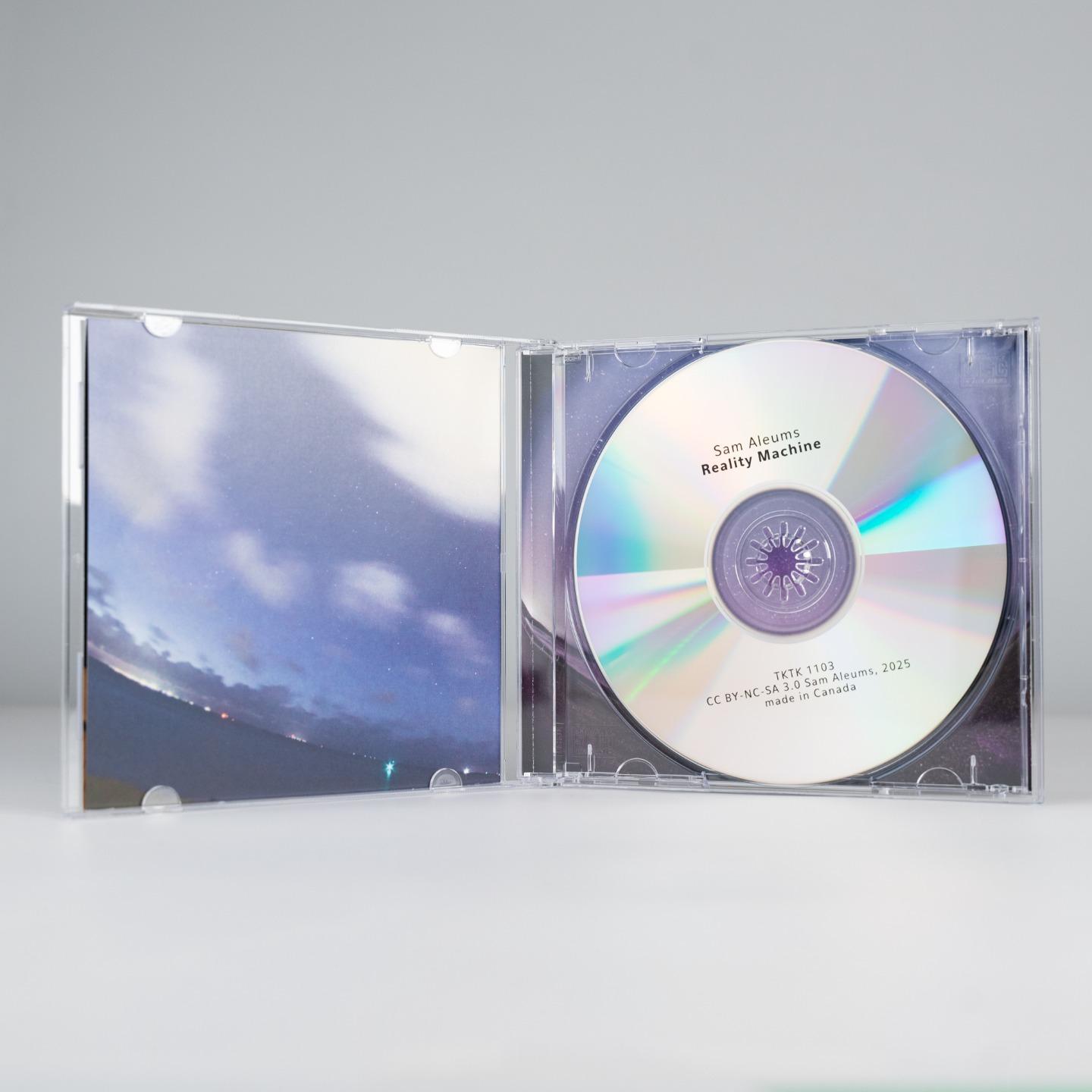 The CD case, open to reveal a shiny silver disc and a continuation of the cover art on the inside flap